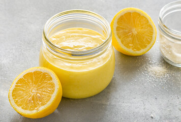Homemade lemon curd or citrus dessert in glass jar close up