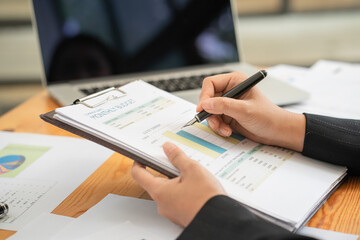 Hand hold pen writing on document.