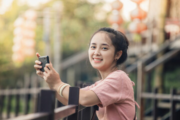 asian woman smiling and taking photo in city vintage.