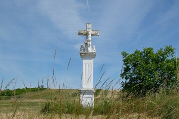 Old roadside stone cross among field. It is made from Pinczow limestone.