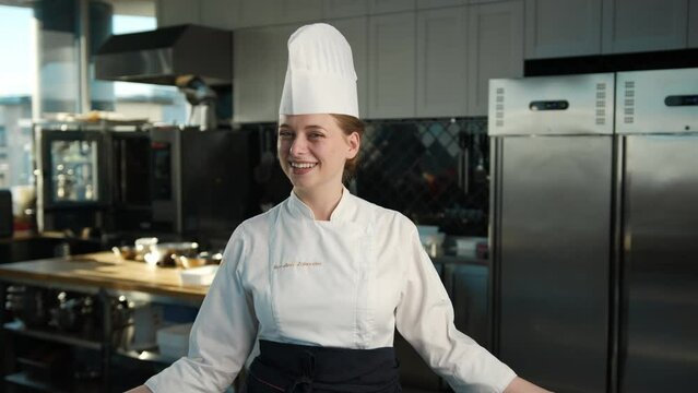 Professional kitchen portrait: Female Chef laughs and dances in the kitchen