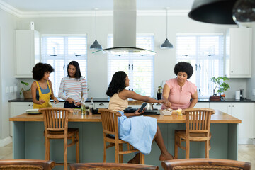 Biracial female friends preparing pizza on kitchen island while spending weekend together at home © WavebreakMediaMicro