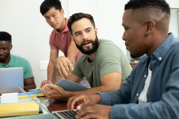 Multiracial male coworkers brainstorming ideas and strategies for achieving business goals