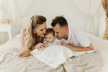 Obraz na płótnie Canvas parent and baby, happy family having fun in bed, portrait happy family.