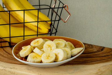 Fresh bananas and bananas cut into pieces in a bowl - stock photo