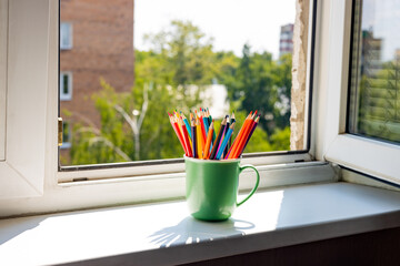 Pencils in a stand on the window, the window is open, summer.