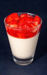 Delicious Italian dessert Panna Cotta with strawberry coulis. Milk dessert with berries.