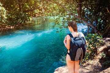 young woman with backpack standing near Rio Blanco in Costa Rica