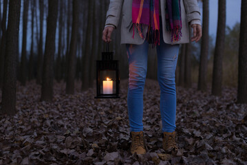 Young woman in the woods walking with lantern at night © Solid photos