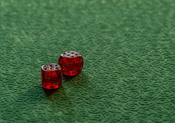 Close up photo of red and white dices on green background. Gambling and luck concept.