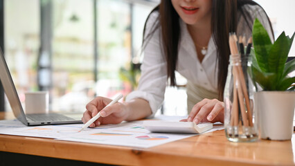 Professional Asian female manager or financial consultant reviewing a financial report