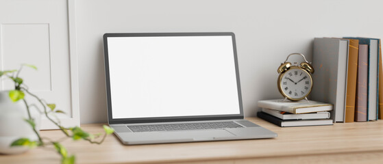 Minimal workspace on wood tabletop over white wall with laptop blank screen mockup