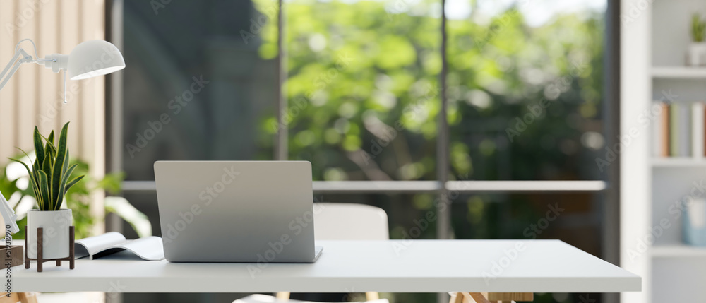 Poster modern stylish workspace with laptop and copy space on the table over blurred office background.