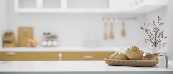 White kitchen tabletop with a bread basket and copy space over blurred minimal kitchen background