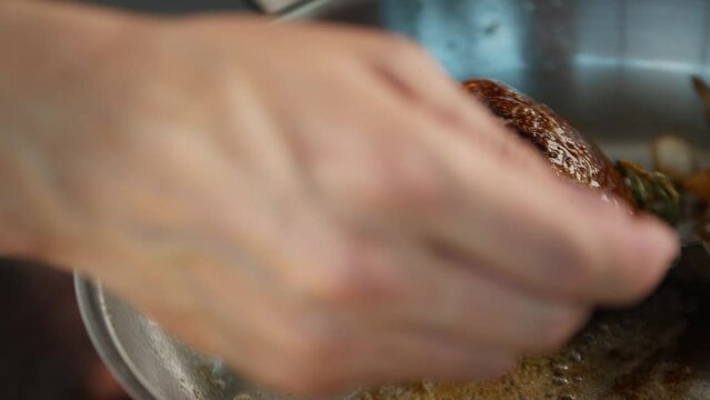 Close-up: Chef pouring sauce over filet mignon while cooking