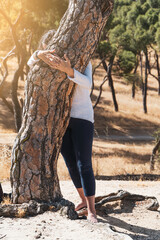 women embracing trees while meditating on the forest. sustainability concept. summer solstice.