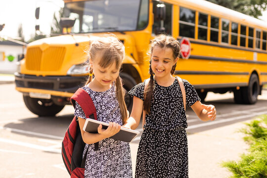 adorable schoolchildren running to school bus