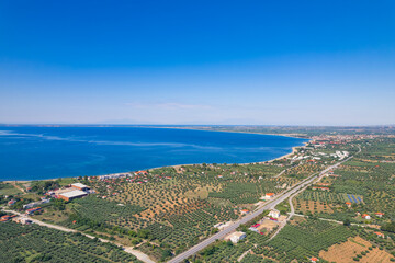 Stunning natural seashore in Greece. Clear blue sky and sea. Lightly populated area, Greek-style whitewashed houses with orange roofs. High quality photo