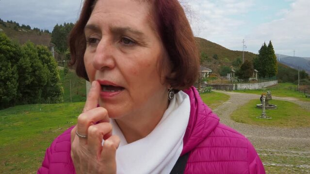 Adult woman applies vaseline on cracked lips on cold day, close up view