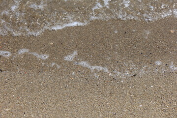 砂浜に静かな波が打ち寄せている風景