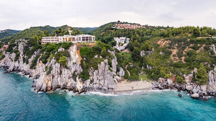 Drone perspective of famous Kassandra cliffs in Greece. Turquoise water and stunning natural seashore mixed with human-built architecture. High quality photo