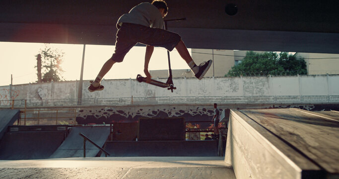 Sporty Men Jumping Tricks On Scooter And Bmx Bike At Urban Skate Park.