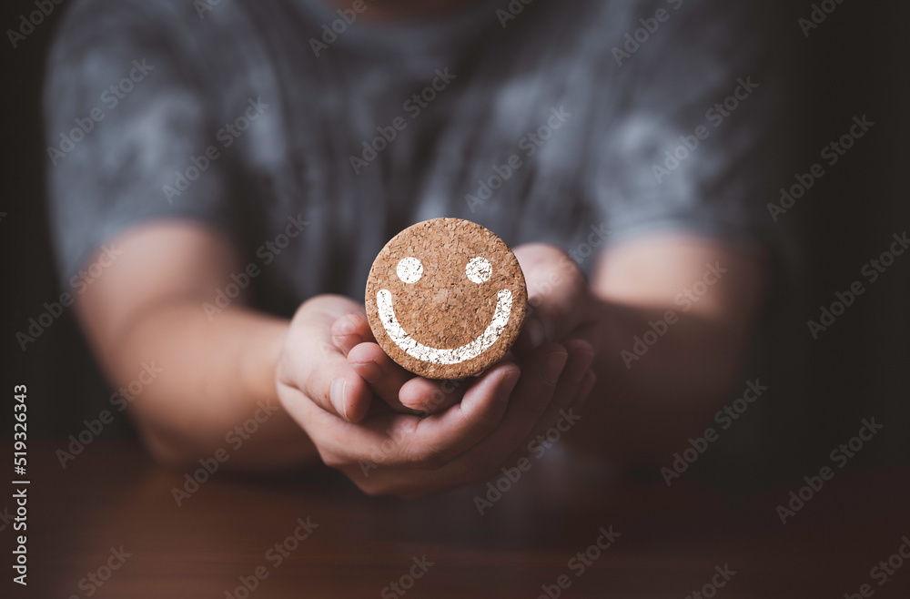 Poster hand holding smile face which print screen on round wooden block for positive thinking mindset conce