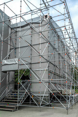 Side view of the installed metal scaffolding for an outdoor stage. Preparation of concert equipment for performance