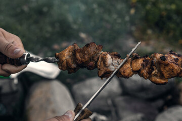 Fried meat on a skewer on a blurry background.