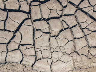 Cracked earth. Drought, lack of moisture. Cracks in the ground. Land in a dry period. Soil texture and dry mud. Dry land.