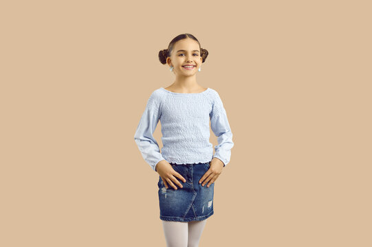 Portrait of cute beautiful joyful preteen girl in stylish clothes on beige studio background. Happy pretty schoolgirl in fashionable casual clothes smiling looking at camera. Isolated.