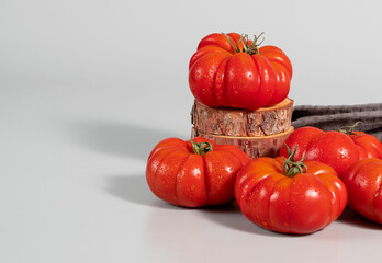 A group of Costoluto big tomatoes on a grey background, textile, space for text