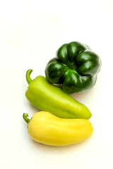 Dark green-to-yellow gradient of sweet peppers on white background, vegetarian lifestyle concept