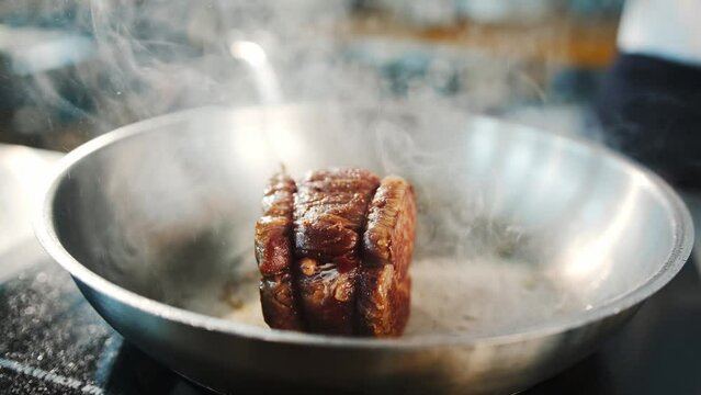 Close-up of a filet mignon being cooked in a frying pan