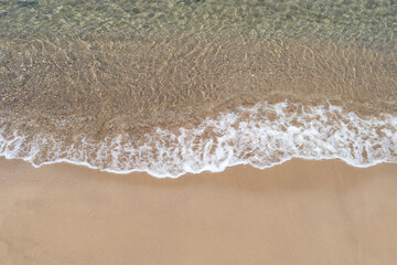 Top view photo of beach sand and ripples with bubbles. 