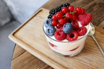 summer desserts with berries in a glass bowl and large glasses of homemade lemonade on a wooden in a cafe	

