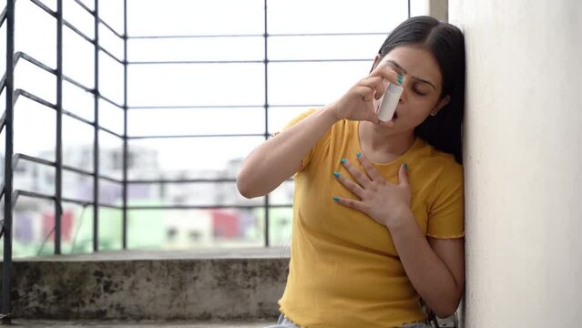 Asthmatic patient catching inhaler having an asthma attack. Young woman having asthma, chronic obstructive pulmonary disease