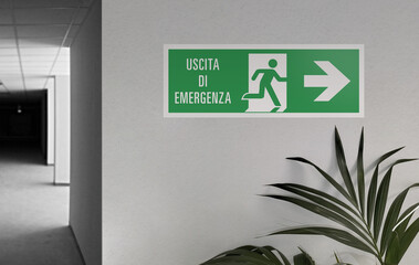 Emergency exit sign in an office corridor. Exit sign, green symbol on a white background.