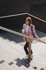 business woman in a pink jacket goes to work in the office and smiles. A successful confident European woman entrepreneur financier or marketer goes to the coworking office. beautiful young smart