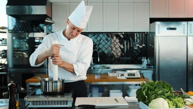 The chef prepares the dish in the professional kitchen of the restaurant.