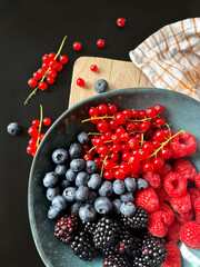strawberries and blueberries, blackberries and red currant in a bowl