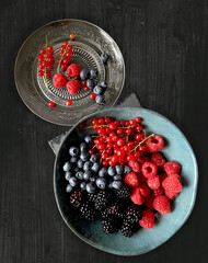 strawberries and blueberries, blackberries and red currant in a bowl