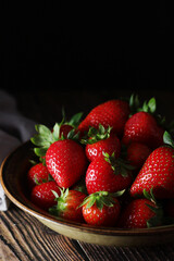 A bowl with ripe bright strawberry in rustic style