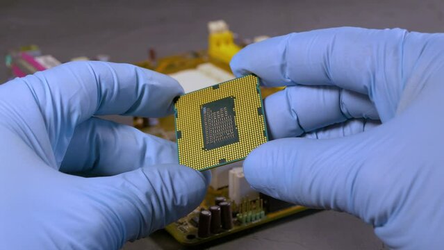 An engineer inspects a processor die for damage. Close-up, selective focus.