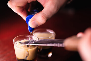 Bartender prepares B52 Shot. Making cocktails at a party