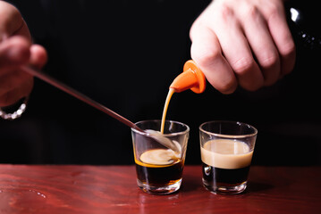 Bartender prepares B52 Shot. Making cocktails at a party, pouring liquor