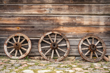 Fototapeta na wymiar Three old wooden wagon wheels