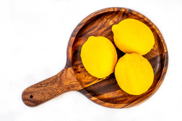 Lemon fruits on wooden plate isolated on white background. Juicy lemon.