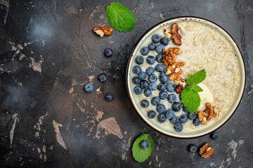 oatmeal porridge with ripe blueberries for healthy breakfast on rustic wooden board. close up Detox and healthy superfoods bowl concept