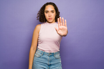 Brunette woman with curly hair putting a stop to violence - obrazy, fototapety, plakaty